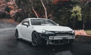 white car damage in a rainy road