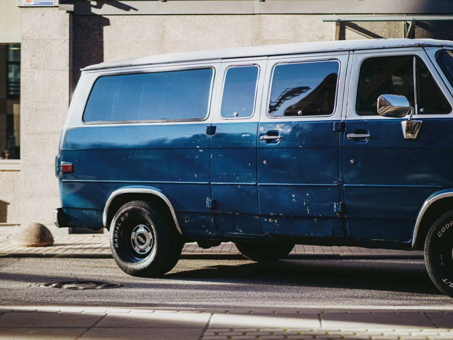 small dents and paint scratches on a blue van